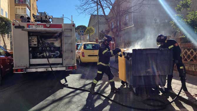Los bomberos apagan un contenedor en la calle Reina Isabel.