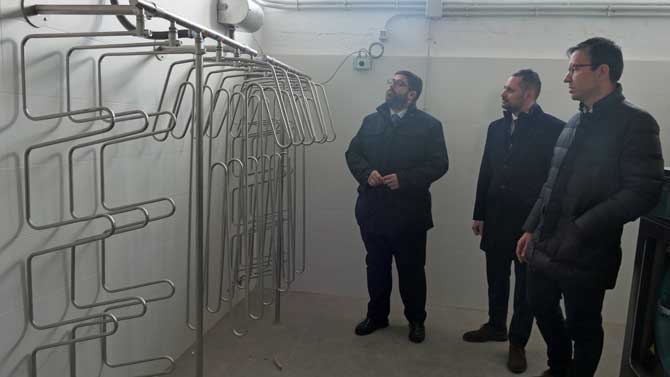 El alcalde observa la secadora de ropa de los bomberos.