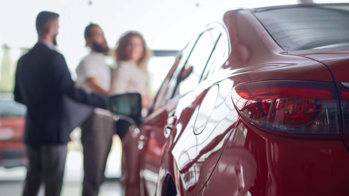 Un vendedor muestra un veh&iacute;culos en un concesionario.