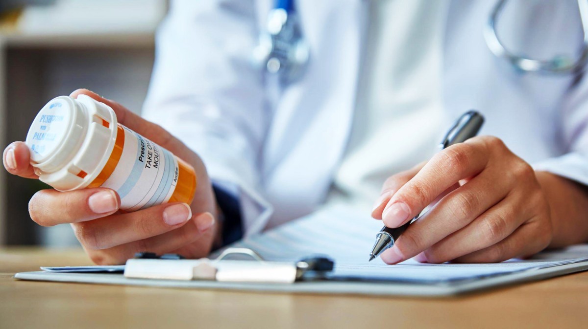 Inagen de un m&eacute;dico elaborando una receta.