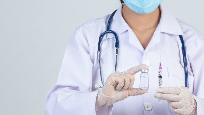 Un sanitario muestra una vacuna.