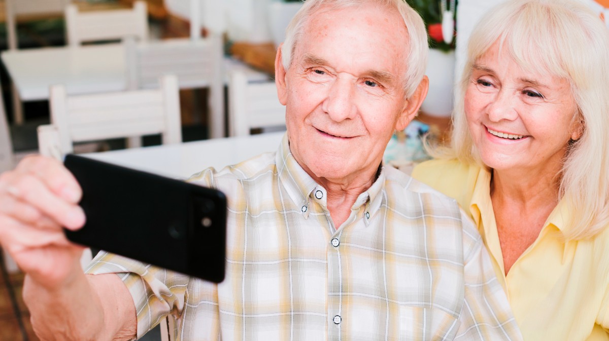 Dos personas mayores se hacen un selfi.