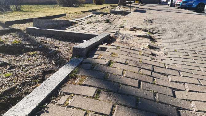 Acera dañada por el arbolado en la plaza de Granada.