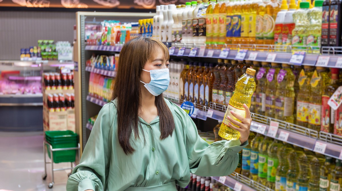 Una mujer adquiere aceite en un supermercado.