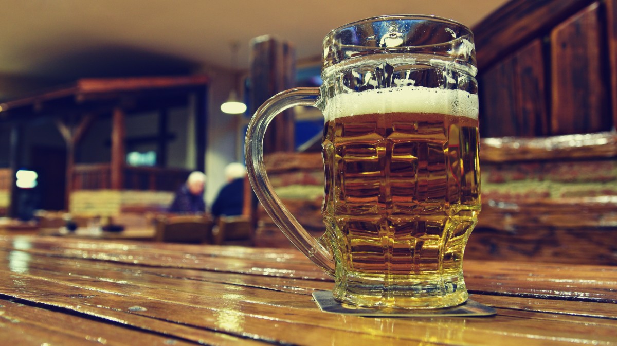 Una ca&ntilde;a de cerveza en la barra de un bar.