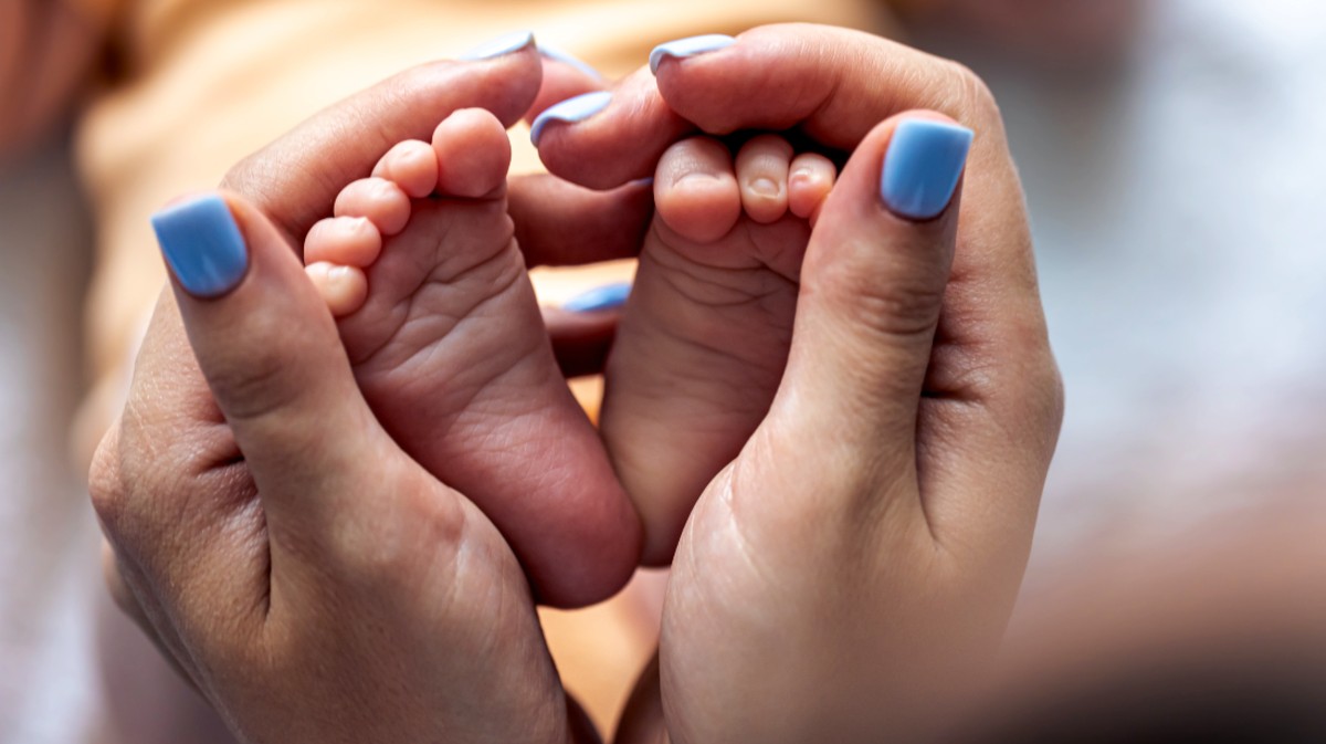 Una madre sujeta los pies de su beb&eacute;.