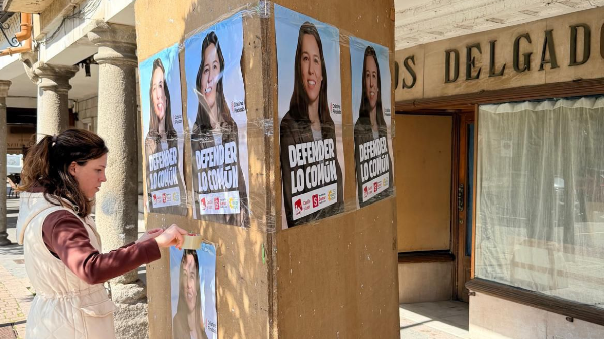 Cristina Pindado colocando carteles de la coalici&oacute;n en Ar&eacute;valo.
