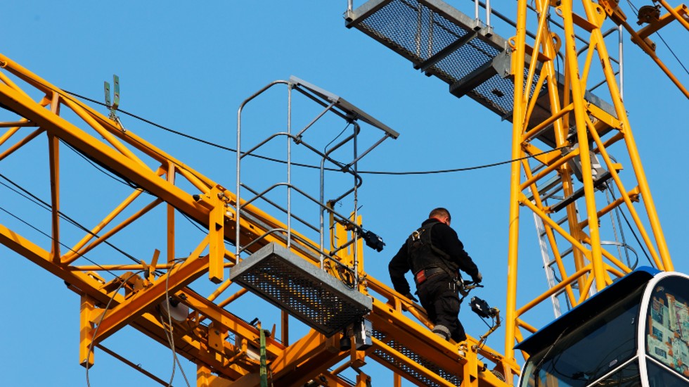 Un trabajador en una gr&uacute;a de una obra.
