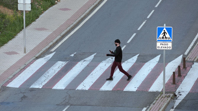 Un peatón transita con mascarilla.