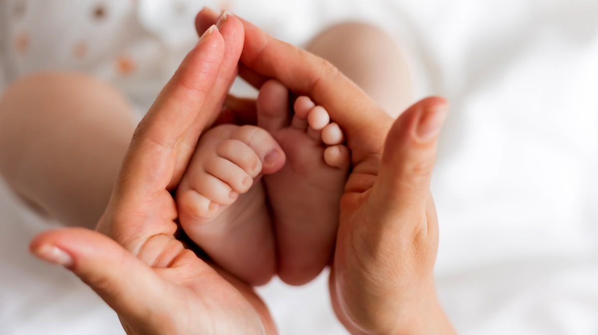 Una madre sujeta los pies de su beb&eacute;.