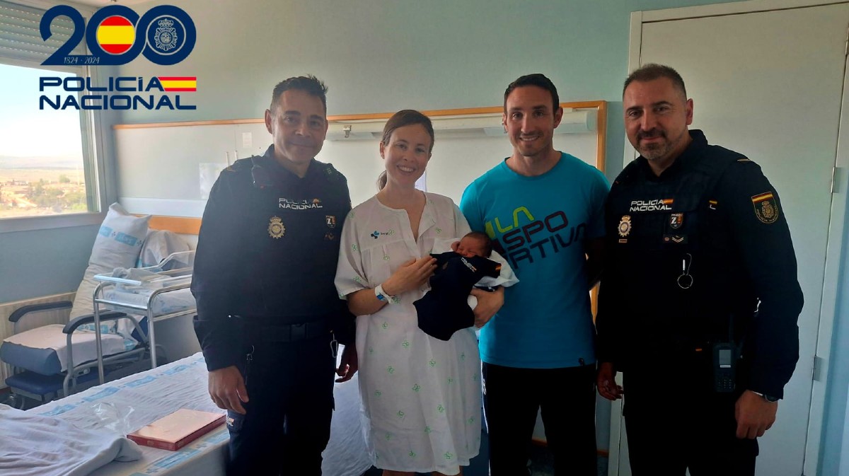 El beb&eacute; y los padres con los agentes que ayudaron en el parto.