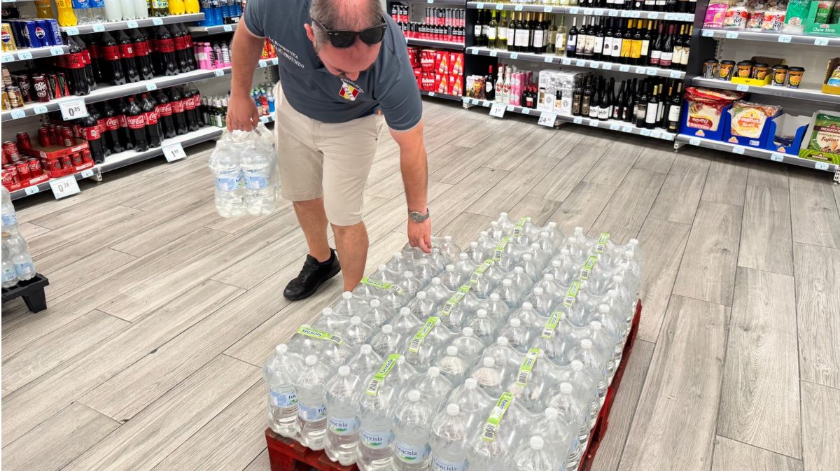 Ciudadano comprando agua embotellada en un supermercado.