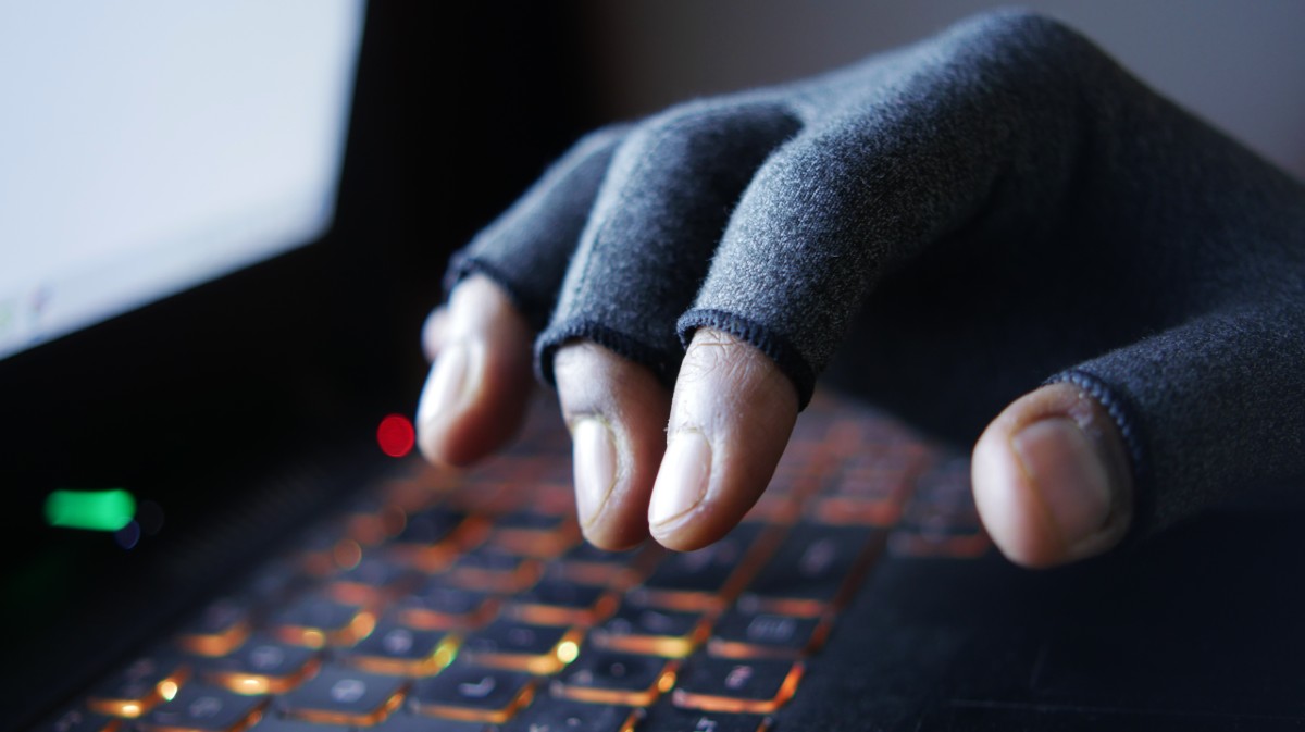 Recreaci&oacute;n de un ciberdelincuente ante el teclado de un ordenador.