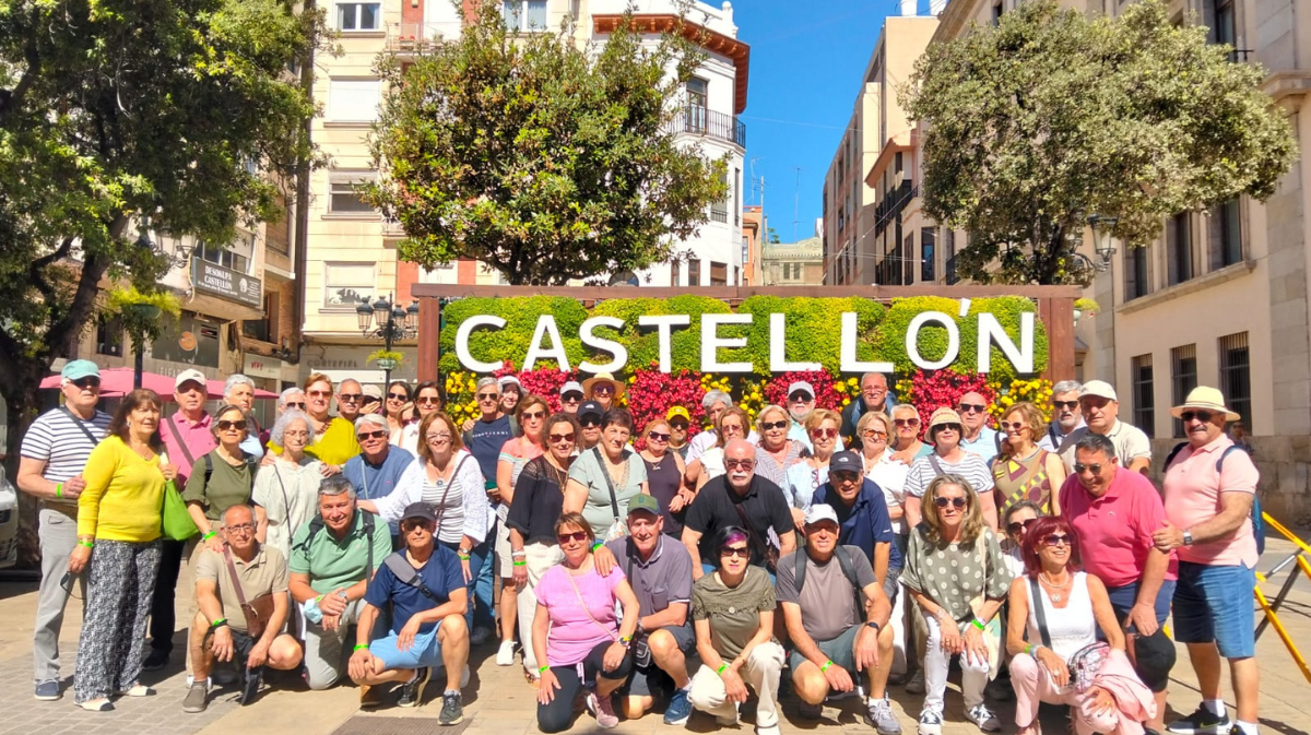 Los excursionistas de la UJP-UGT de &Aacute;vila posan junto al cartel floral de Castell&oacute;n durante su recorrido por el litoral mediterr&aacute;neo.