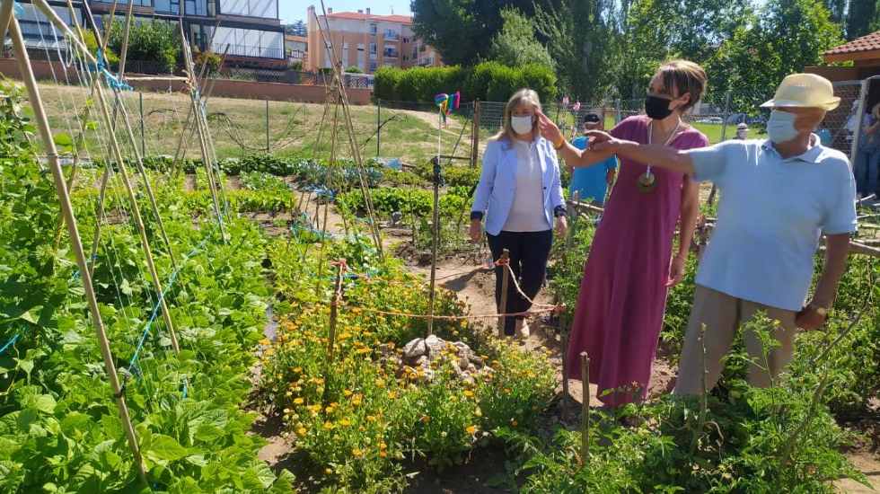 Un participante muestra los huertios urbanos a las concejalas.