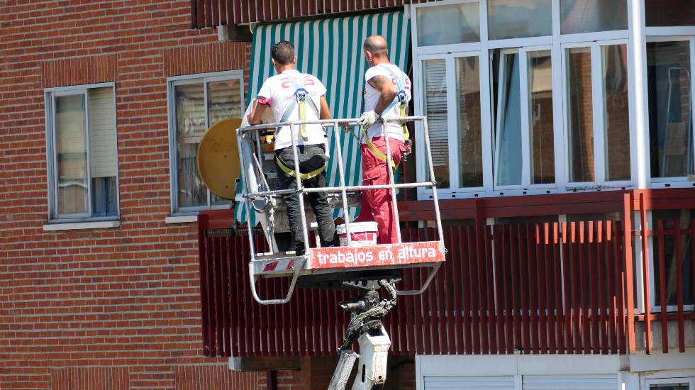 Dos operarios trabajan en un edificio en Ávila.