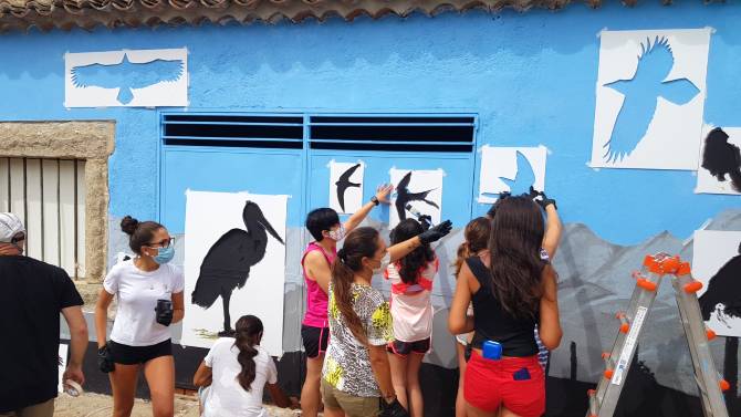 Dibujan aves en una fachada de El Herradón de Pinares.