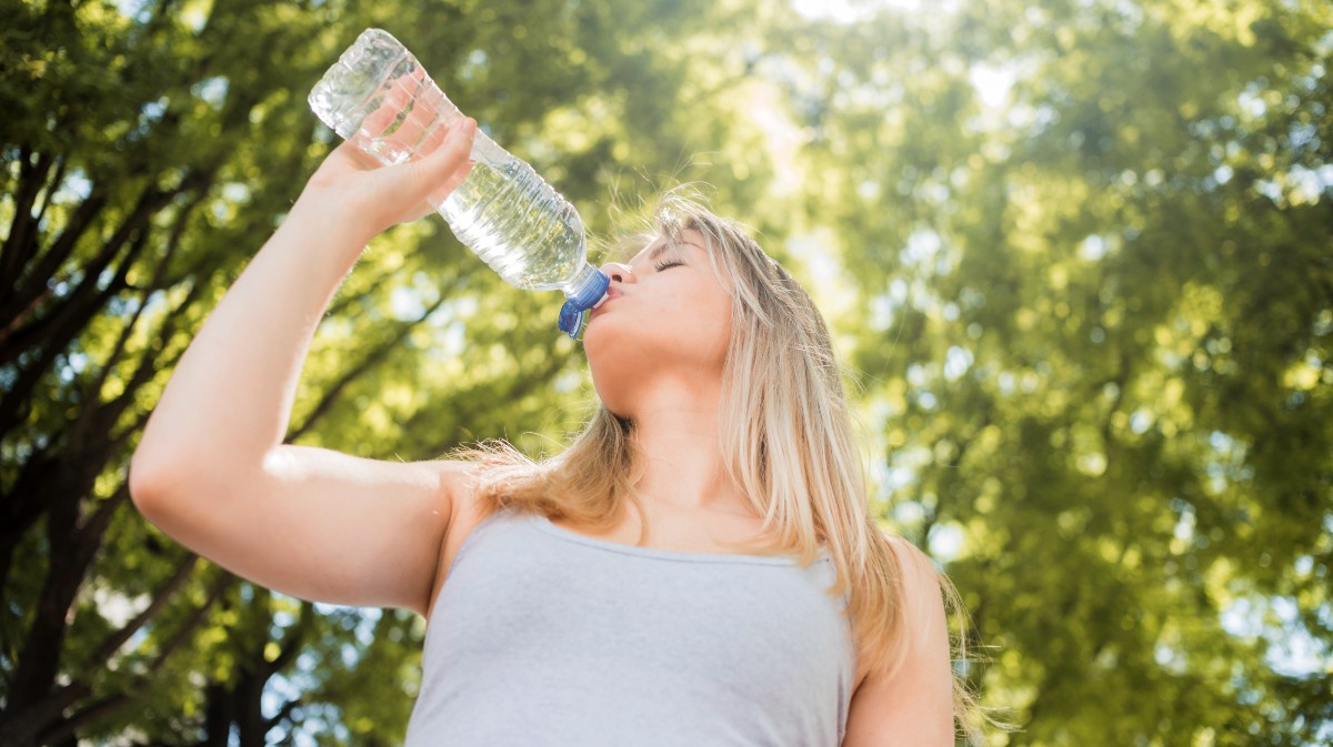 Una mujer se hidrata ante el calor.