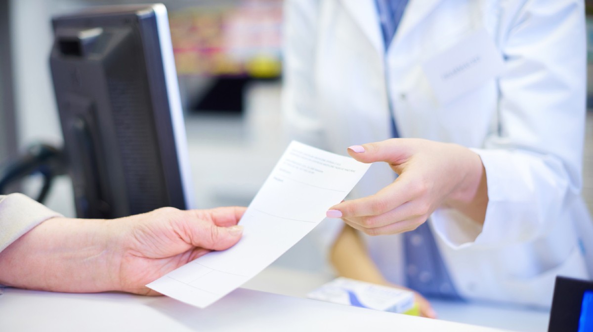 Un cliente presenta una receta m&eacute;dica en una farmacia.
