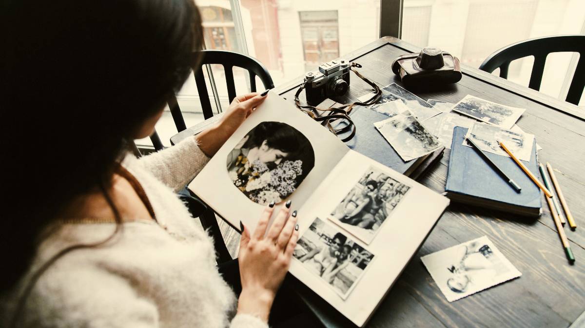 Una mujer mira fotografías antiguas.