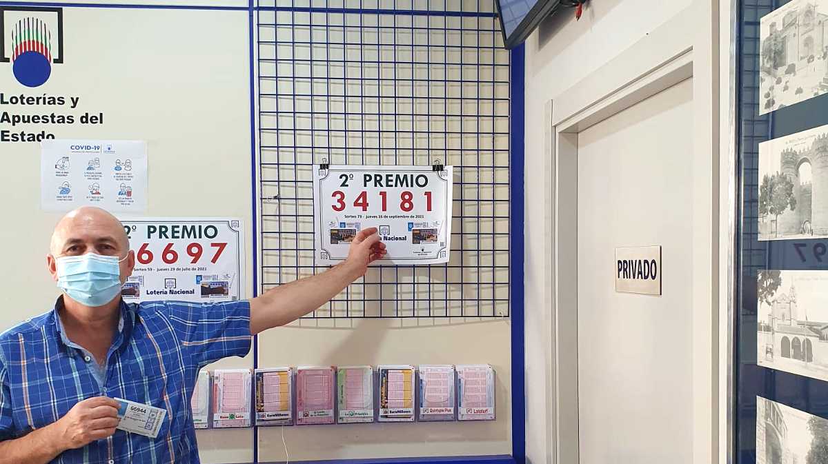 El propietario del bar Paraíso muestra el número premiado.