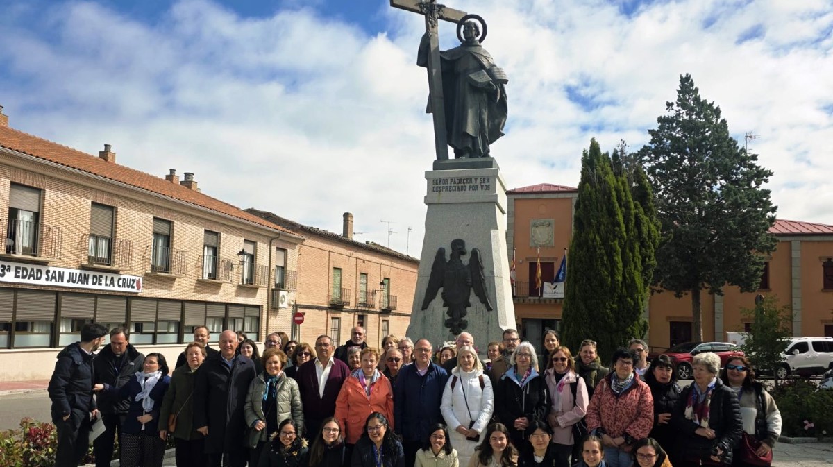 Un grupo de peregrinos ante la estatua de San Juan de la Cruz en Fontiveros.