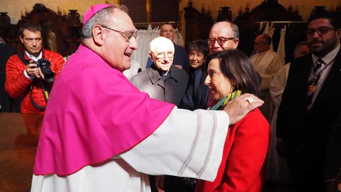 El obispo de Ávila y la ministra de Defensa se saludan.