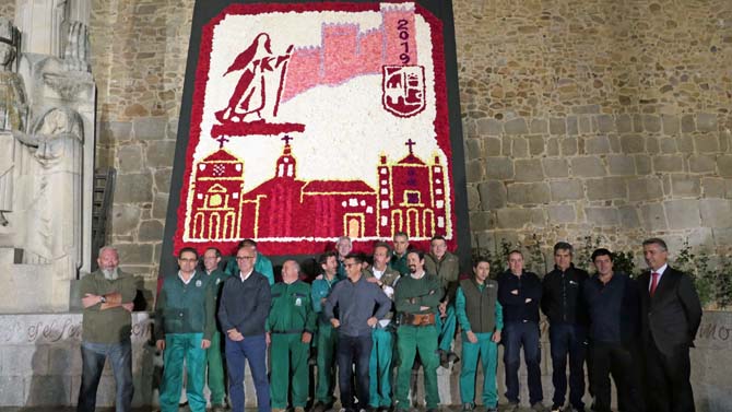 Operarios del servicio de jardines ante el mural dedicado a Santa Teresa.