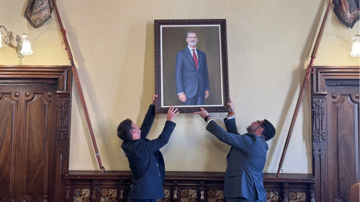 Diego del Pozo y Jes&uacute;s Manuel S&aacute;nchez colocan el retrato en la pared del sal&oacute;n de plenos