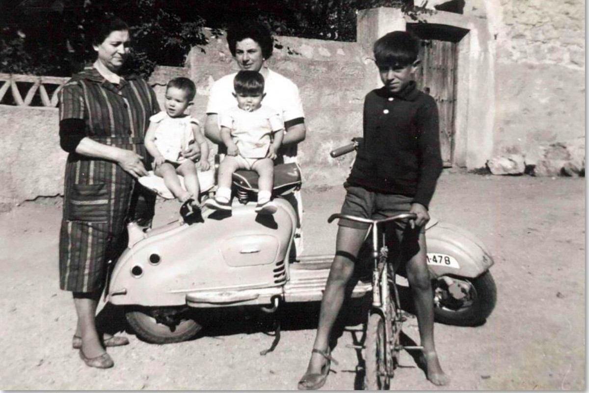 Antonio Sáez en bicicleta y niños en la moto. Años 50.