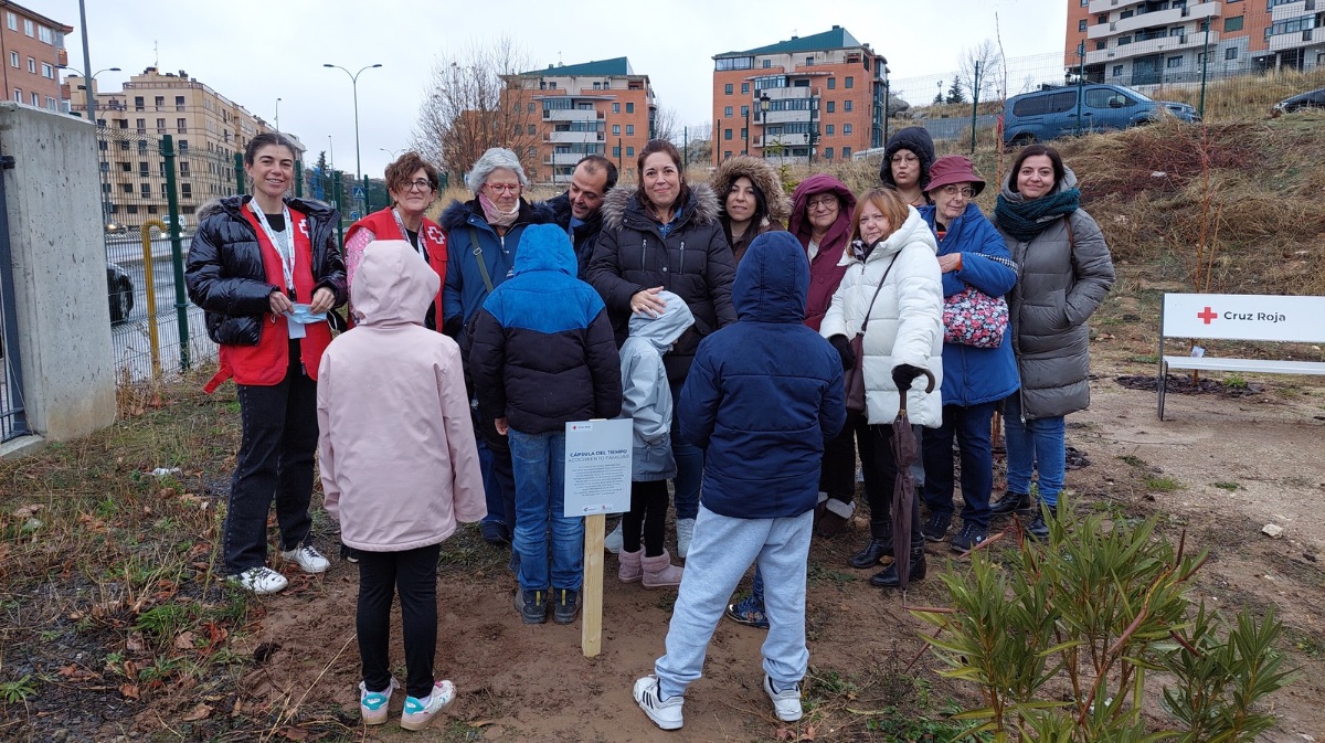 Familias y personal de Cruz Roja enterrando la c&aacute;psula del tiempo